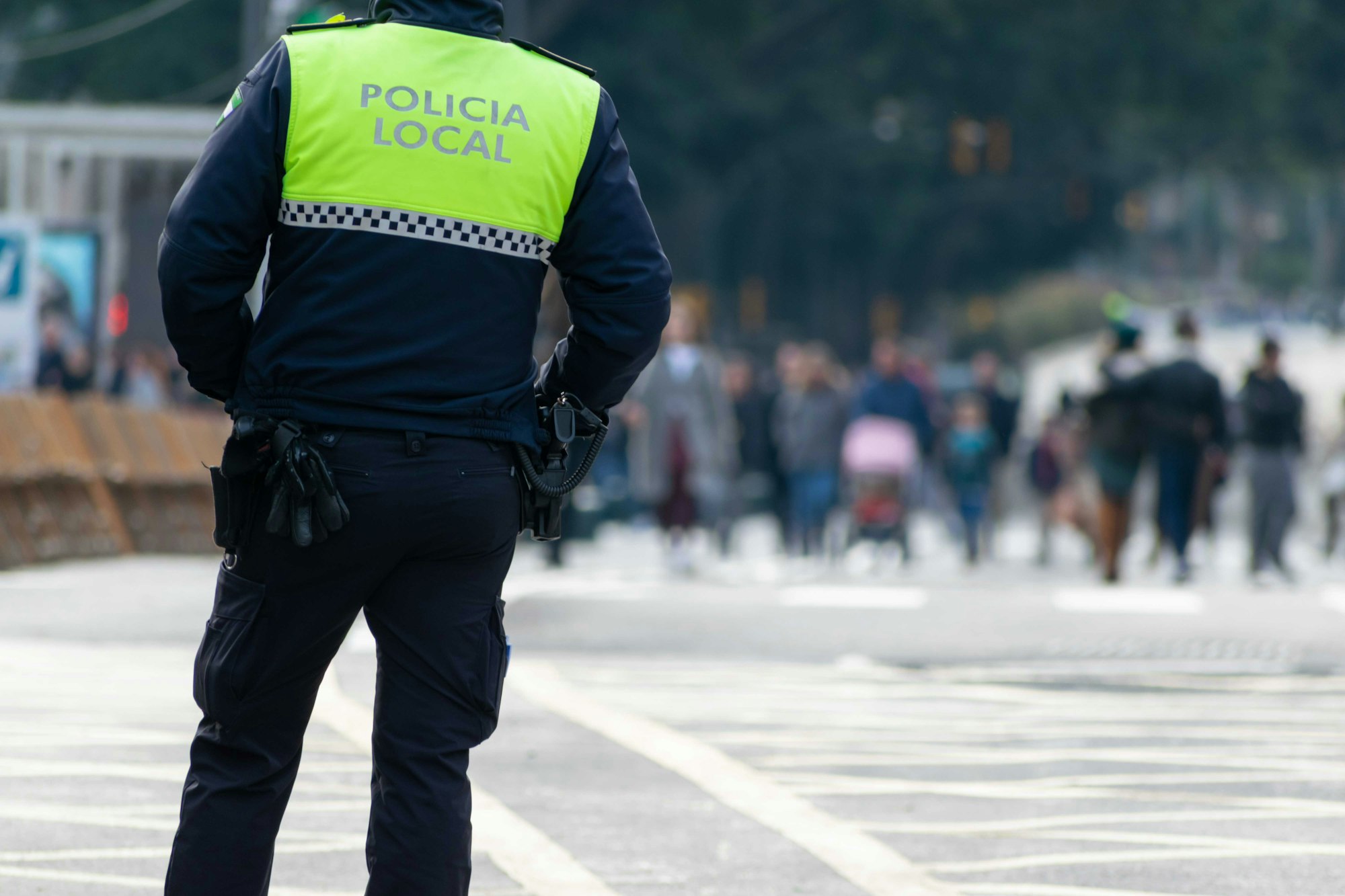 Closeup shot of a police officer with "local police" written on the uniform in Spanish